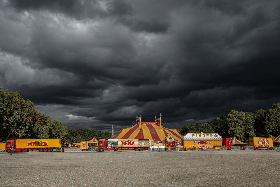 Circustenten met een broeiende storm op de achtergrond.