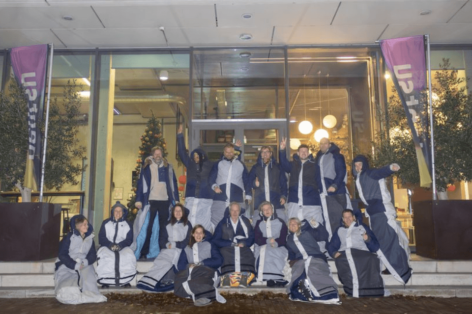 Deelnemers aan de buitenslaapactie in hun Sheltersuit