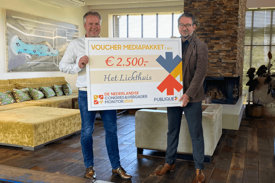 Wim Schrumph (mede-eigenaar Het Lichthuis) krijgt de waardecheque overhandigd door Edwin Nunnink (hoofdredacteur Publique)